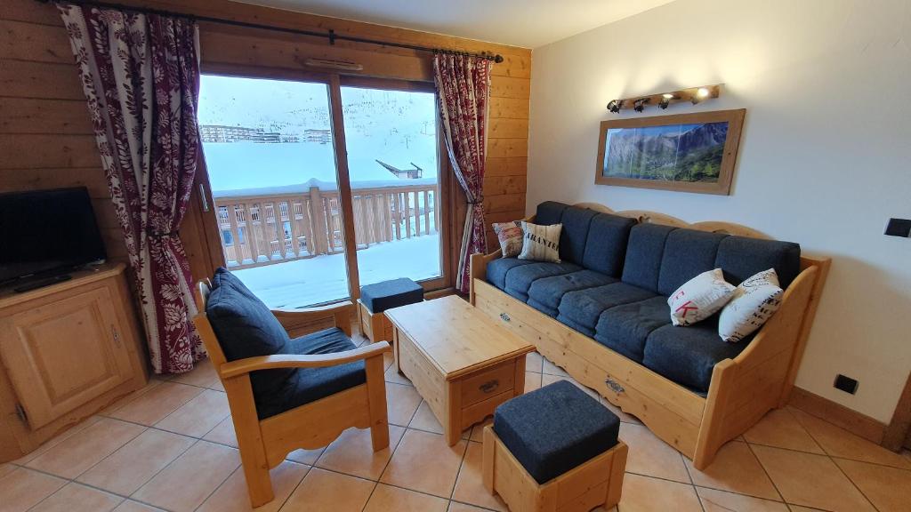 un salon avec un canapé et une grande fenêtre dans l'établissement Tignes2100 - Le Télémark, à Tignes