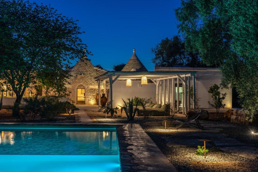 une maison avec piscine la nuit dans l'établissement Trulli cicale e olive, à Ceglie Messapica