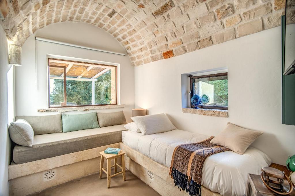 un salon avec un canapé et une fenêtre dans l'établissement Trulli cicale e olive, à Ceglie Messapica 52 autres photos