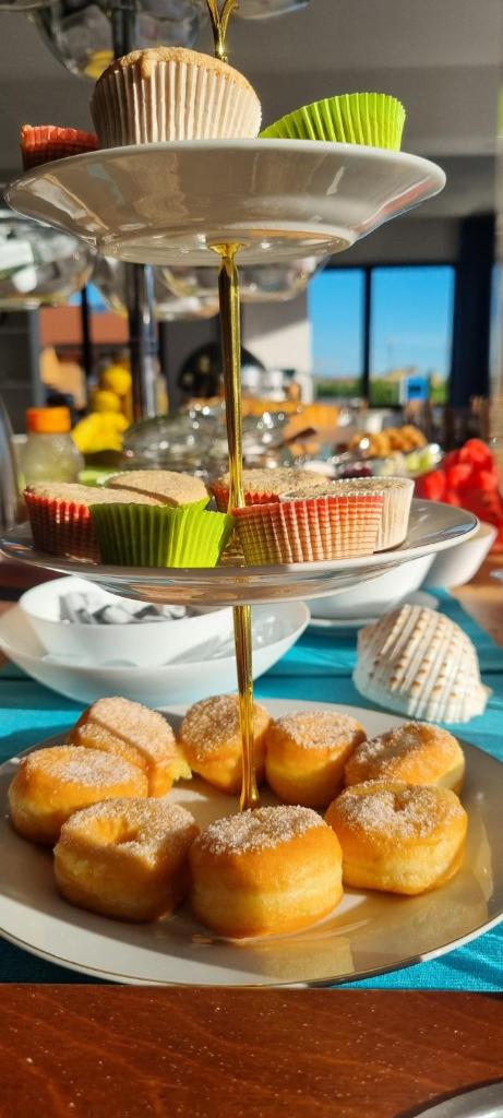 un plateau de beignets sur une table avec des assiettes de nourriture dans l'établissement Hotel Mare Blu -- boutique, à Pineto