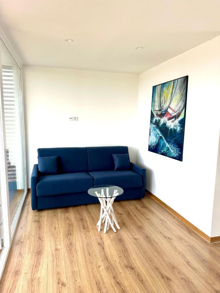 un salon avec un canapé bleu et une table dans l'établissement Borgo Rosso Terra, à Gallipoli