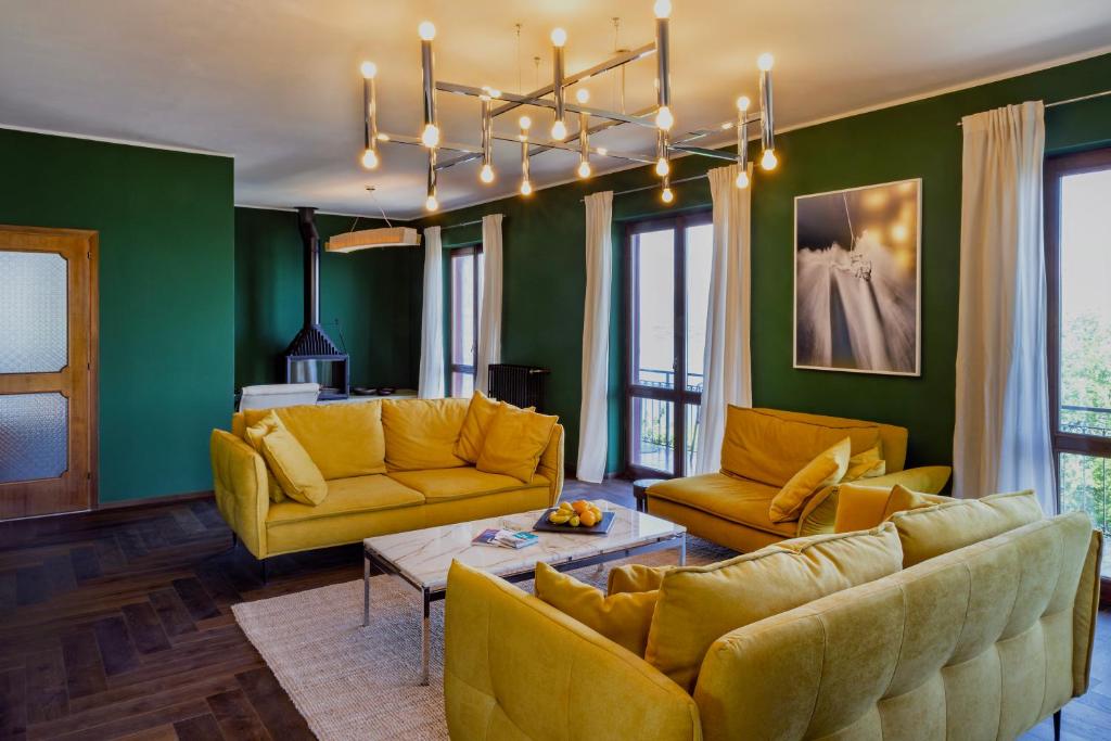 d'un salon avec des meubles jaunes et des murs verts. dans l'établissement Villa LM - Private Villa, Lake View, Salt Pool, à Belgirate