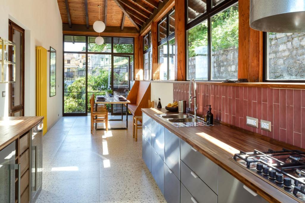 - une cuisine avec un comptoir et quelques fenêtres dans l'établissement Villa LM - Private Villa, Lake View, Salt Pool, à Belgirate