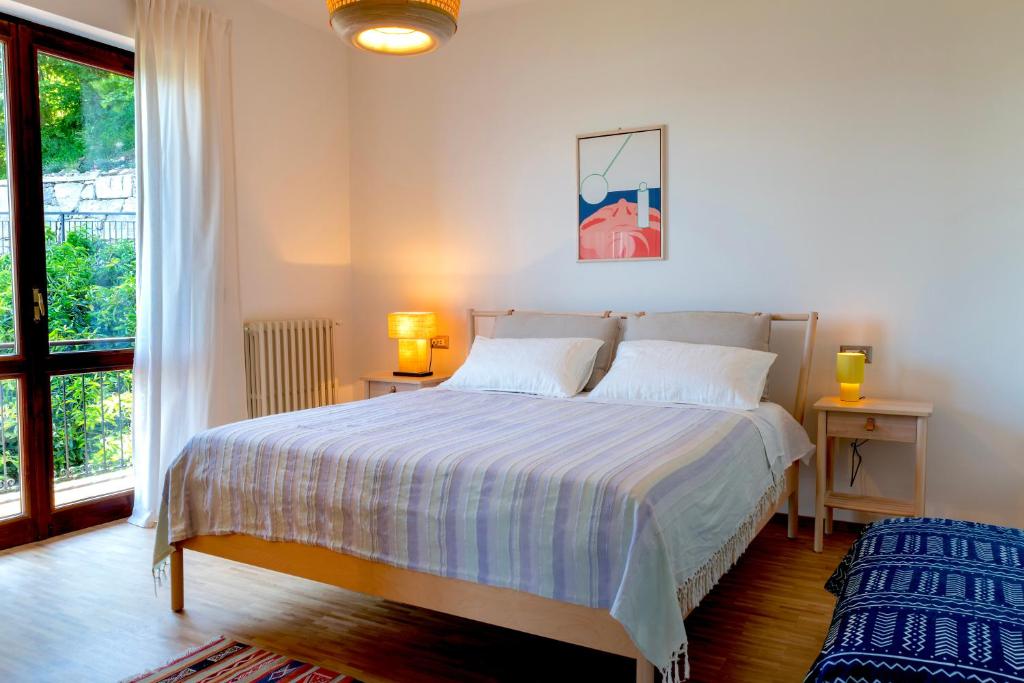 une chambre avec un lit et une grande fenêtre dans l'établissement Villa LM - Private Villa, Lake View, Salt Pool, à Belgirate