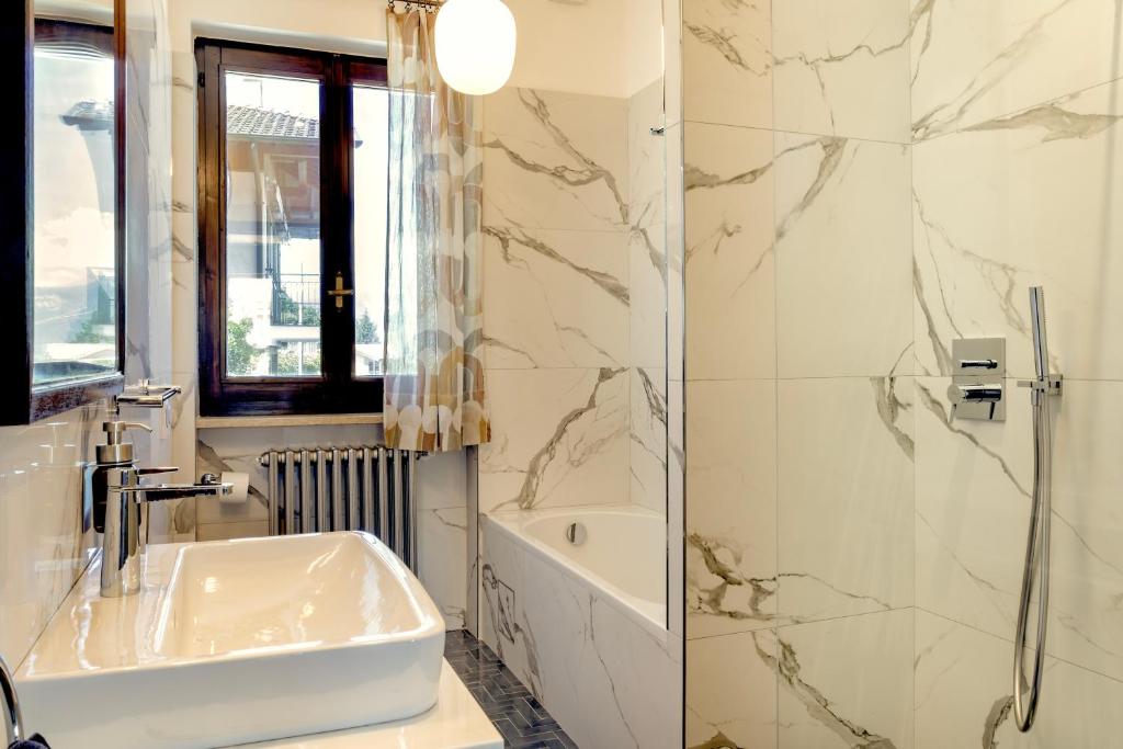 une salle de bain blanche avec un lavabo et une douche dans l'établissement Villa LM - Private Villa, Lake View, Salt Pool, à Belgirate