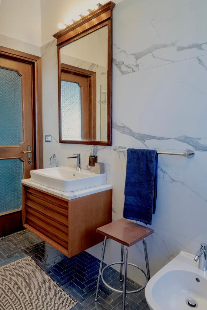 La salle de bains est pourvue d'un lavabo, d'un miroir et d'un tabouret. dans l'établissement Villa LM - Private Villa, Lake View, Salt Pool, à Belgirate 34 autres photos