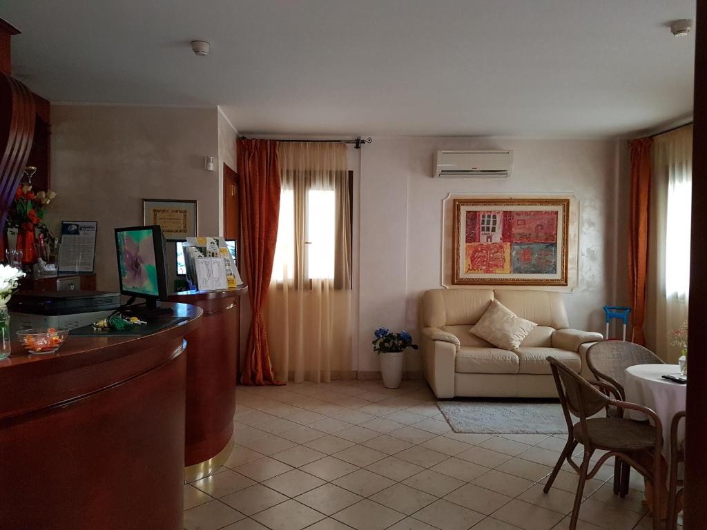 un salon avec un canapé et une table dans l'établissement Hotel Ristorante Rinelli, à Margherita di Savoia