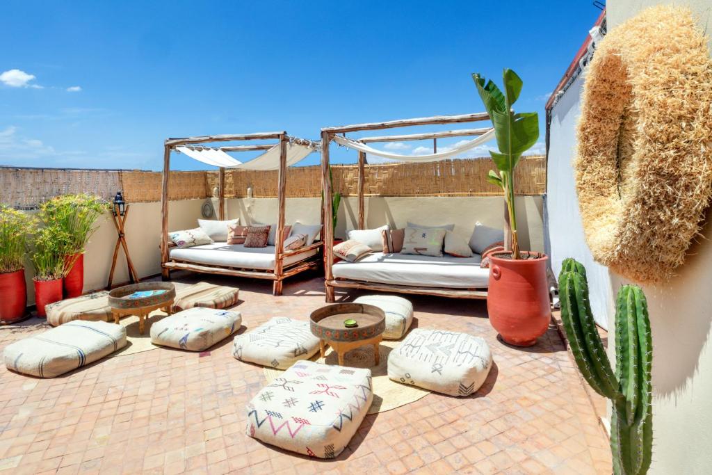un patio avec des lits et des tables et un cactus dans l'établissement Dar Alif, à Marrakech