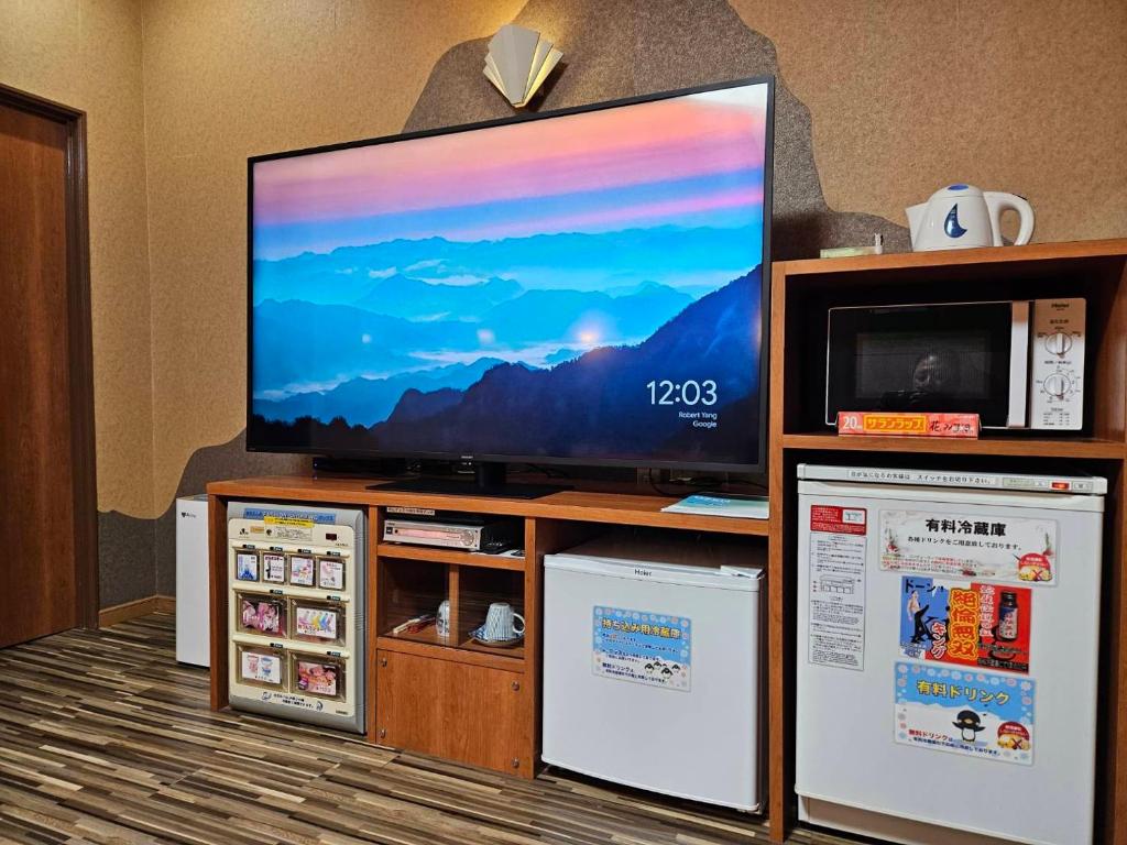 - une télévision à écran plat installée au-dessus d'un centre de divertissement dans l'établissement ホテル 花みずき, à Tuyama