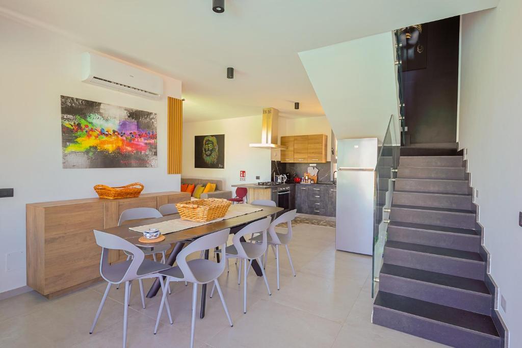 une cuisine avec une table et des chaises ainsi qu'un escalier dans l'établissement Dimora Masi di GN Real Escapes, à Castellammare del Golfo