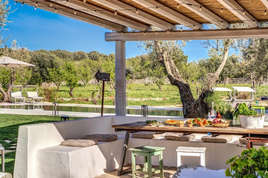 un patio extérieur avec une table et des chaises dans l'établissement Trullo La Sacchina, à Ostuni