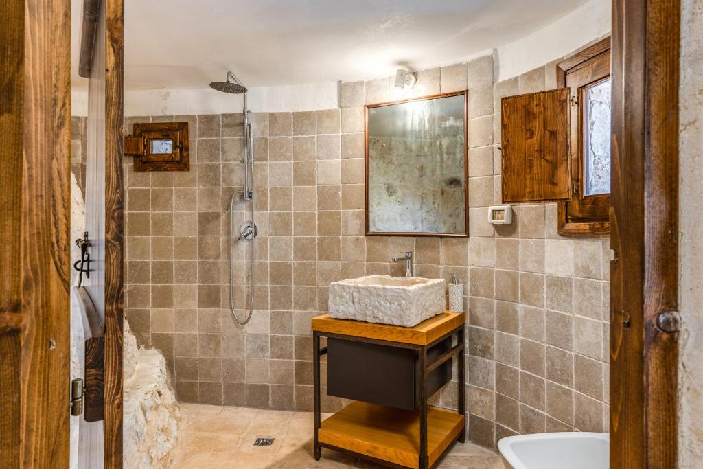 une salle de bain avec un lavabo et une douche dans l'établissement Trullo La Sacchina, à Ostuni 28 autres photos