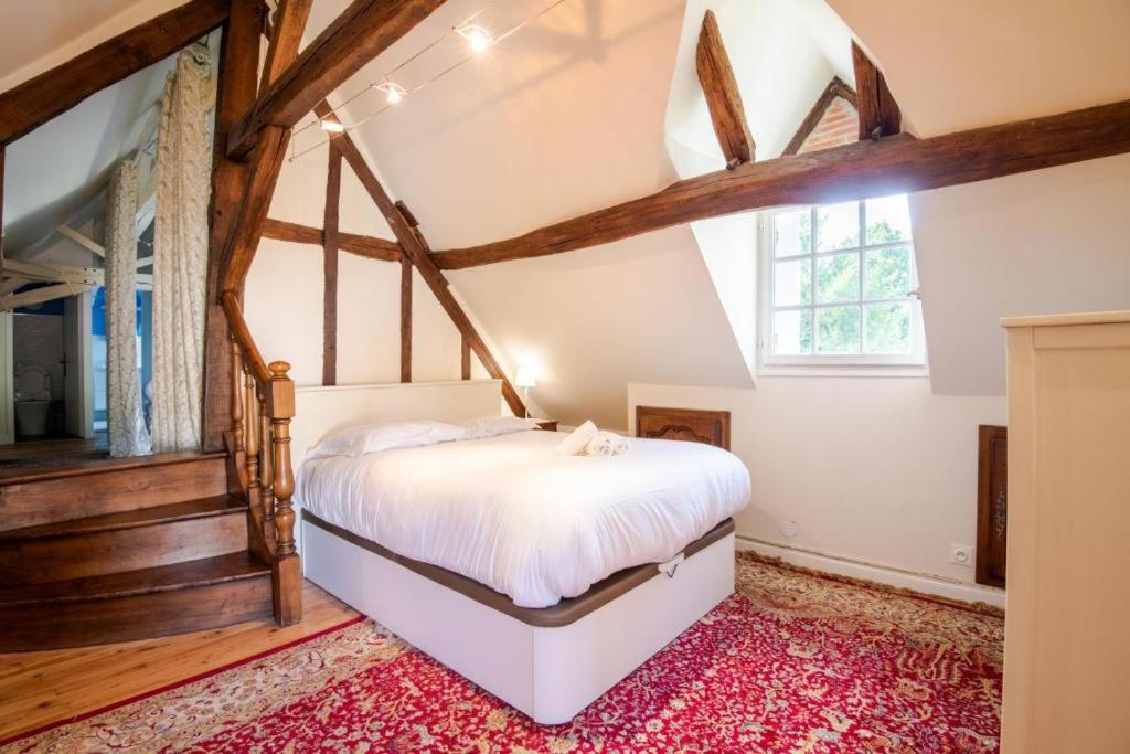 une chambre avec un lit et une grande fenêtre dans l'établissement Gîte Le Prieuré, à Reugny