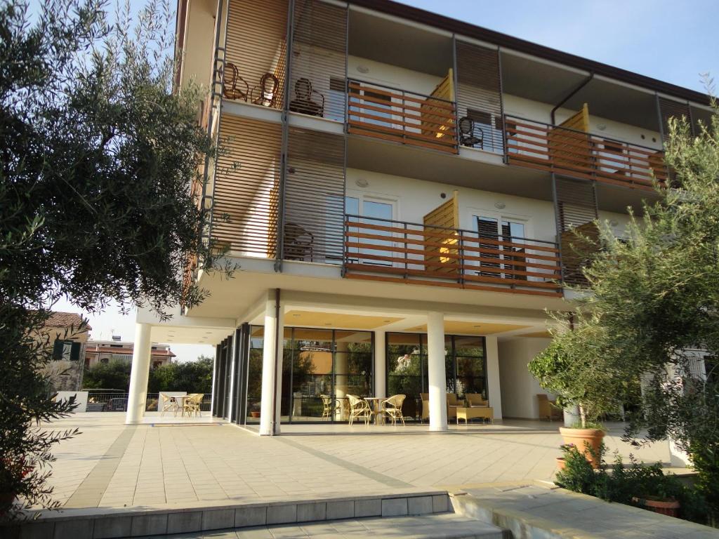 un immeuble d'appartements avec un balcon et un patio dans l'établissement Elaia Garden Hotel, à Sperlonga
