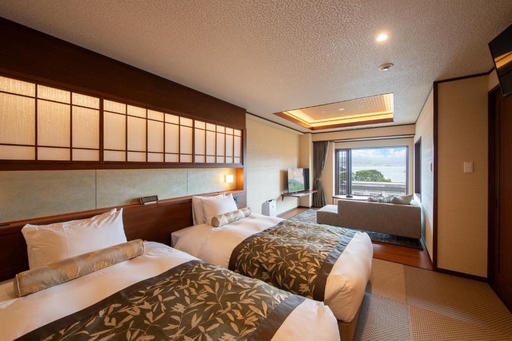 une chambre d'hôtel avec deux lits et une fenêtre dans l'établissement Hotel Saginoyu, à Suwa