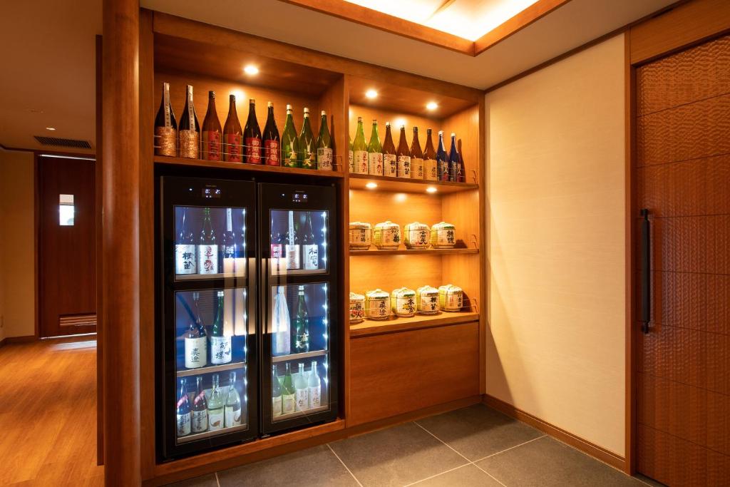 - un bar avec de nombreuses bouteilles d'alcool sur les étagères dans l'établissement Hotel Saginoyu, à Suwa