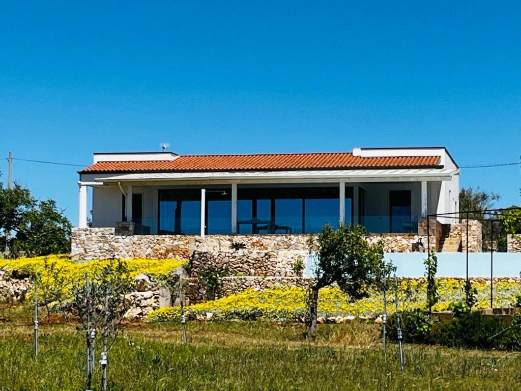 une maison en pierre avec un toit rouge dans l'établissement Villa degli Ulivi, à Torre Vado