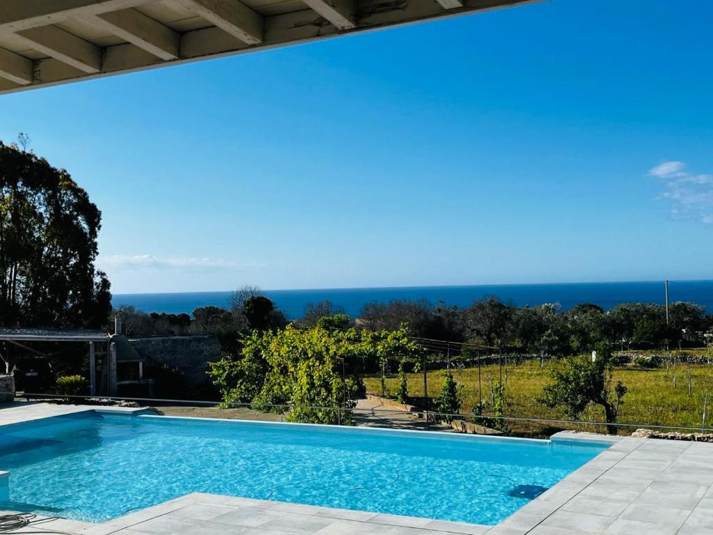 une piscine avec l'océan en arrière-plan dans l'établissement Villa degli Ulivi, à Torre Vado