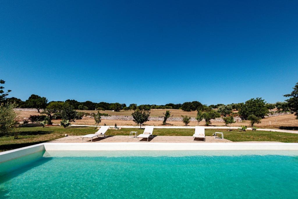 - une piscine avec 2 chaises longues et des ahaps dans l'établissement HelloAPULIA Typical Cottage Lamia delle Murge - Private Pool & Scenic Hilltop Retreat - Pet friendly, à Ostuni