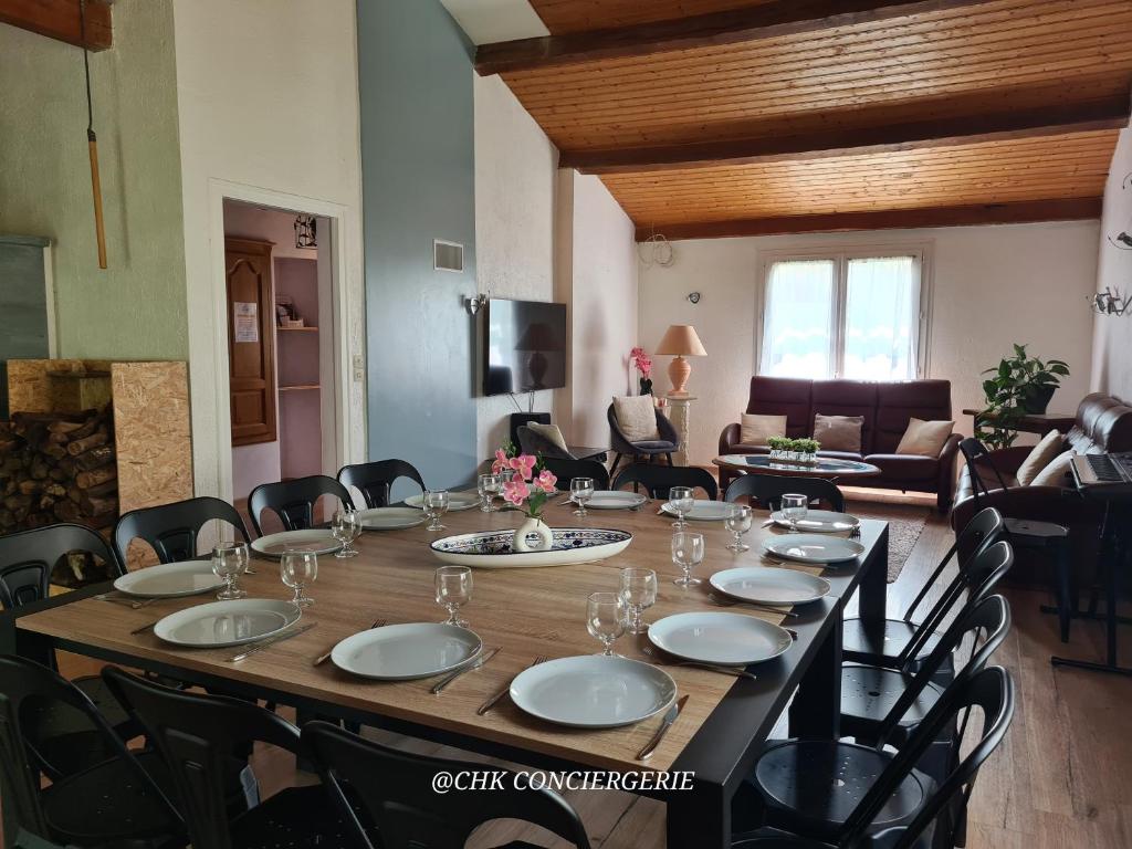 une grande table en bois dans une pièce avec des chaises et un canapé dans l'établissement La Casa - Gîte familal - 15min from Puy duFou, à Mauléon