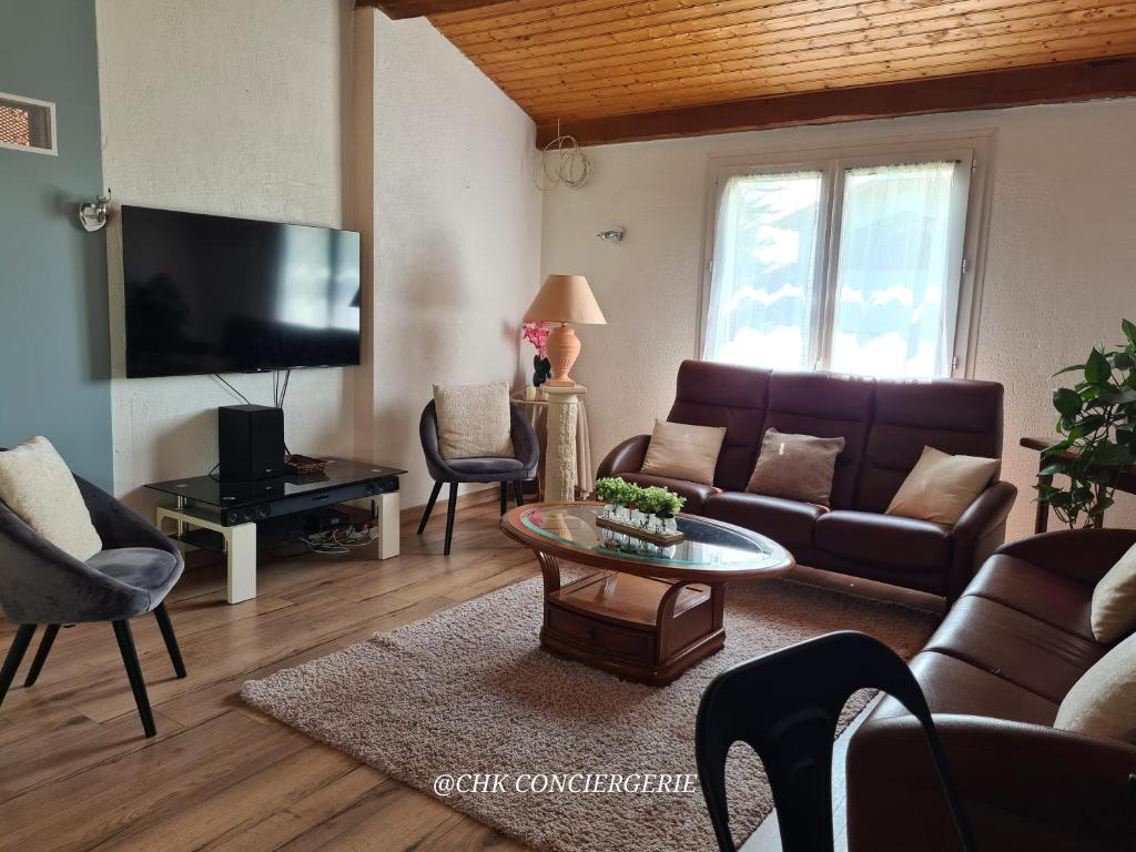 un salon avec un canapé et une table dans l'établissement La Casa - Gîte familal - 15min from Puy duFou, à Mauléon