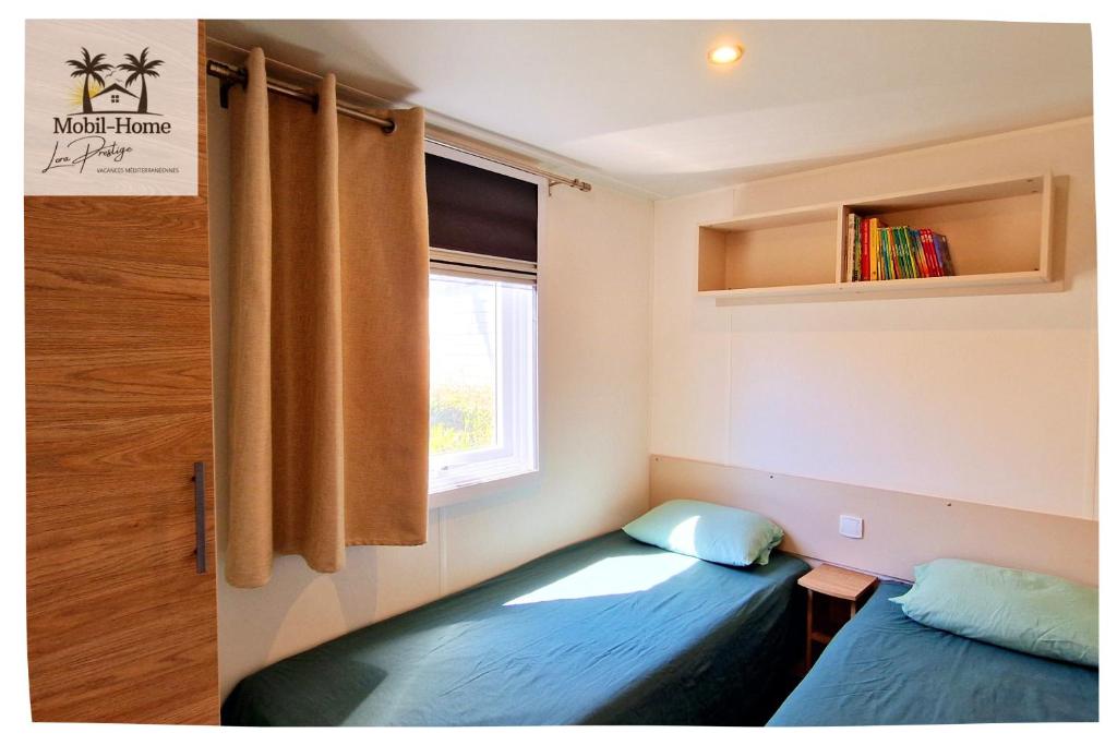 une petite pièce avec un lit et une fenêtre dans l'établissement Mobil-home aux Sables du Midi chez Catherine et Bernard., à Valras-Plage