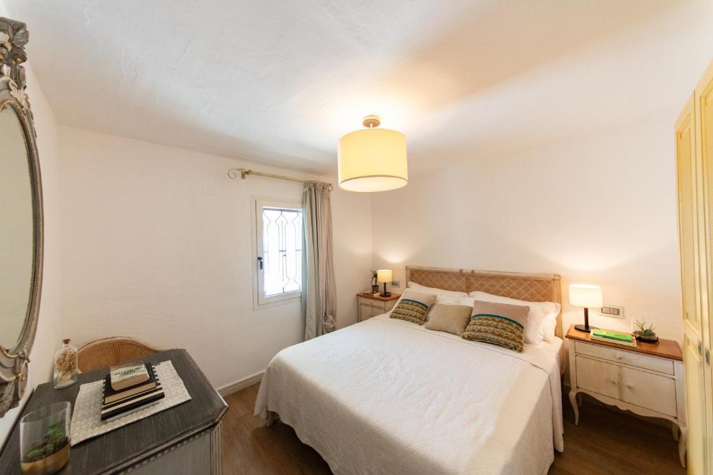 une chambre avec un lit blanc et un miroir dans l'établissement Villa Bianca, à Villasimius 58 autres photos