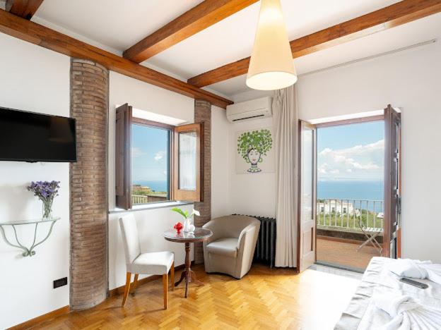 - un salon avec un lit et une vue sur l'océan dans l'établissement Villa Carolina Sorrento Private Heated Pool and Sea View, à Sorrente