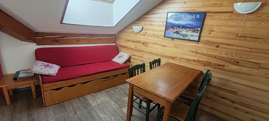 - une salle à manger avec un canapé rouge et une table dans l'établissement Appartement 42M² pour 4/6 personnes à VALMEINIER 1800, à Valmeinier