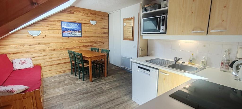 - une cuisine et une salle à manger avec une table dans une petite maison dans l'établissement Appartement 42M² pour 4/6 personnes à VALMEINIER 1800, à Valmeinier