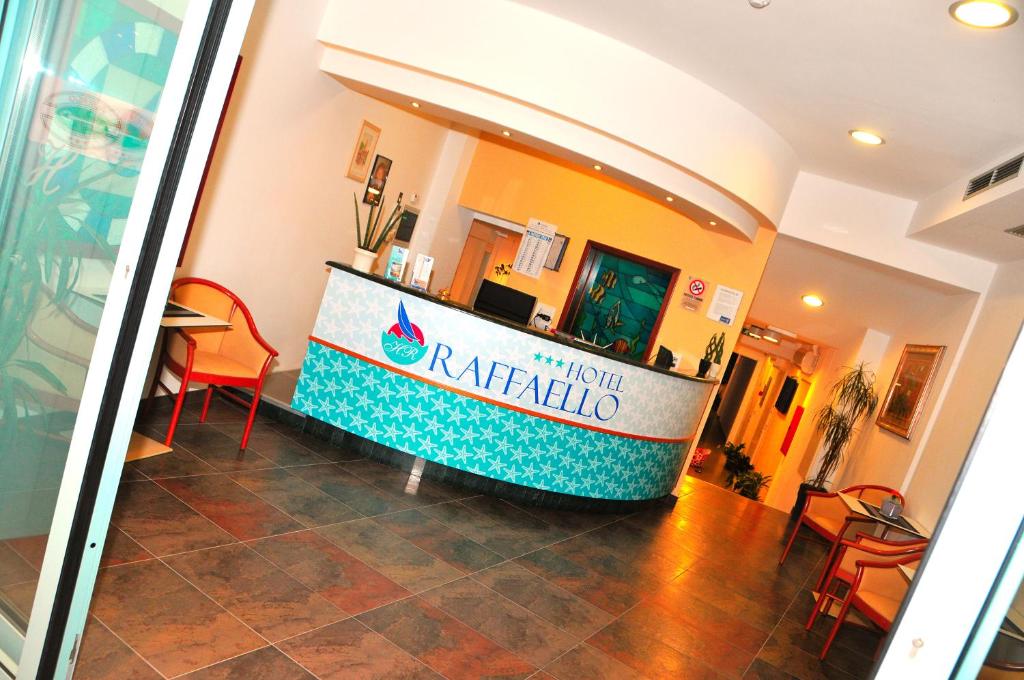 - un hall d'un hôtel avec une table et des chaises dans l'établissement Hotel Raffaello, à Caorle