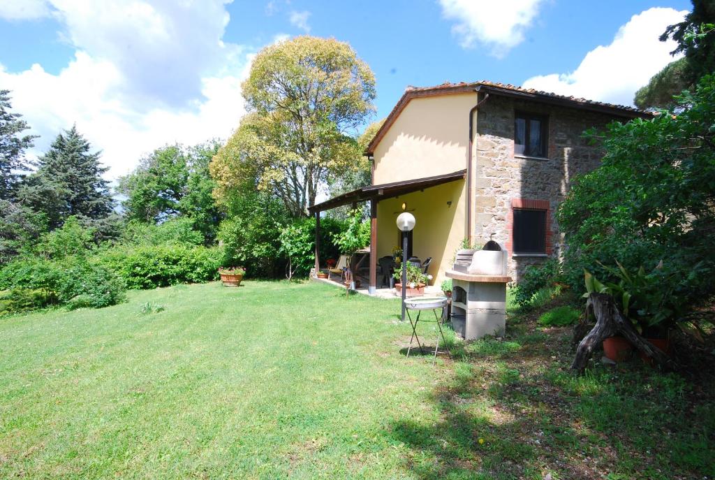 une petite maison avec une pelouse devant elle dans l'établissement Casina, à Gaiole in Chianti