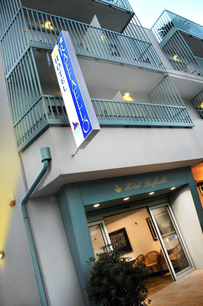 un bâtiment avec une enseigne sur le côté dans l'établissement Hotel Raffaello, à Caorle