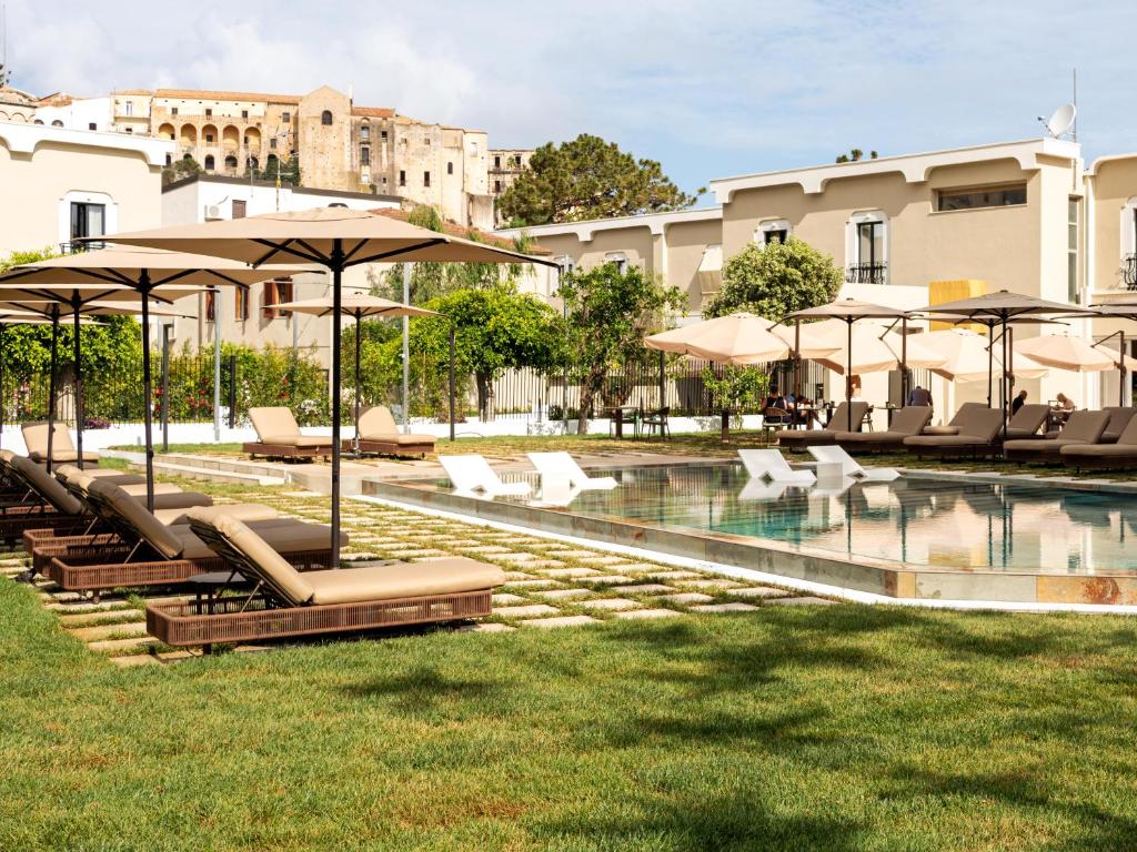 une piscine avec chaises longues et parasols dans l'établissement ananea Tropea Yachting Resort, à Tropea