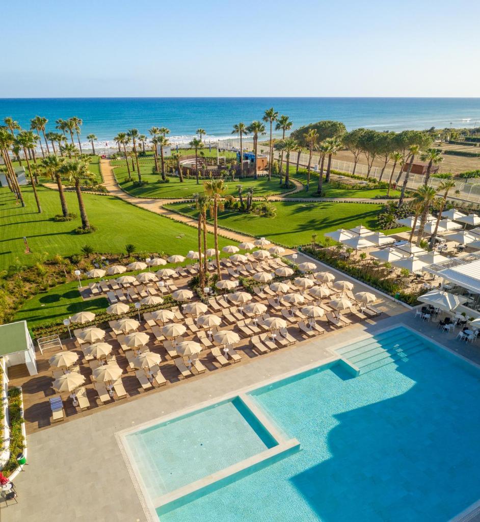une vue aérienne d'un complexe hôtelier avec piscine et plage dans l'établissement Mangia's Himera Resort, à Campofelice di Roccella