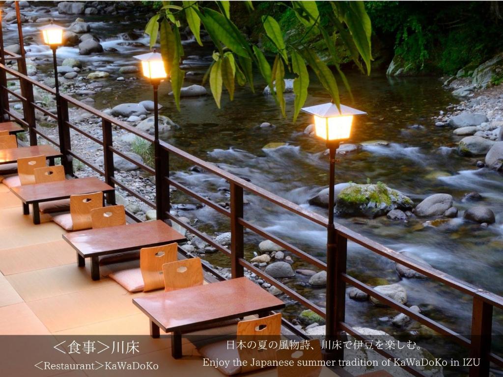 une rangée de bancs à côté d'une rivière avec des lumières dans l'établissement Tatsuta Ryokan, à Izu 37 autres photos