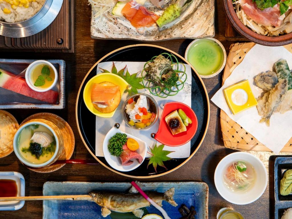 une table avec des assiettes de nourriture sur une table dans l'établissement Tatsuta Ryokan, à Izu