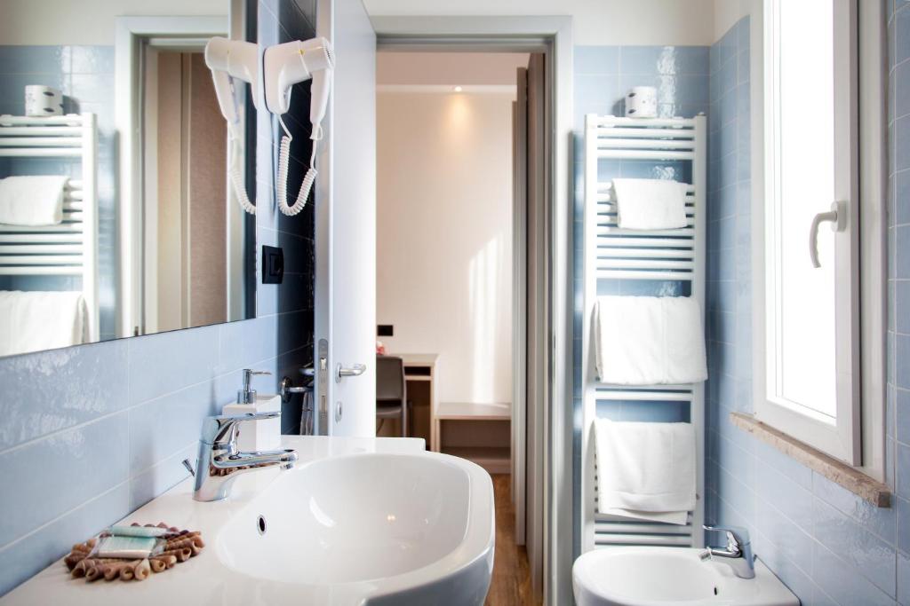 une salle de bain avec un lavabo blanc et un miroir dans l'établissement My Place Hotel, à Rimini