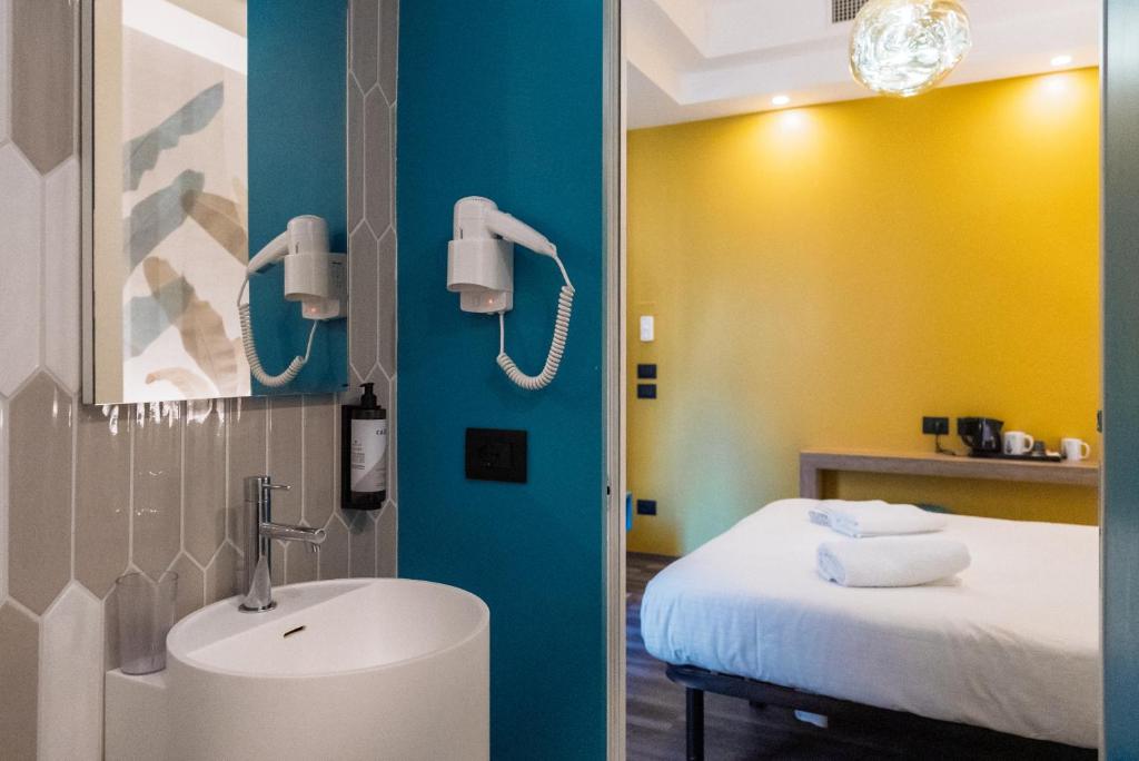 une salle de bain avec un lavabo et un lit dans l'établissement Design Hotel Astra B&B, à Misano Adriatico