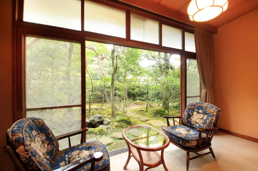 une chambre avec deux chaises et une grande fenêtre dans l'établissement Bansuirou Fukuzumi, à Hakone