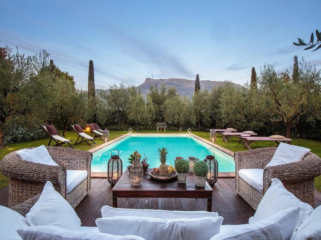 - une piscine avec des chaises et une table à côté dans l'établissement Villa in Camaiore with Pool & Tuscan Views, à Camaiore