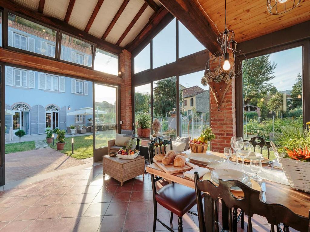 une véranda avec une table et des chaises ainsi qu'une grande fenêtre dans l'établissement Villa in Marlia with Pool near Lucca, à Marlia
