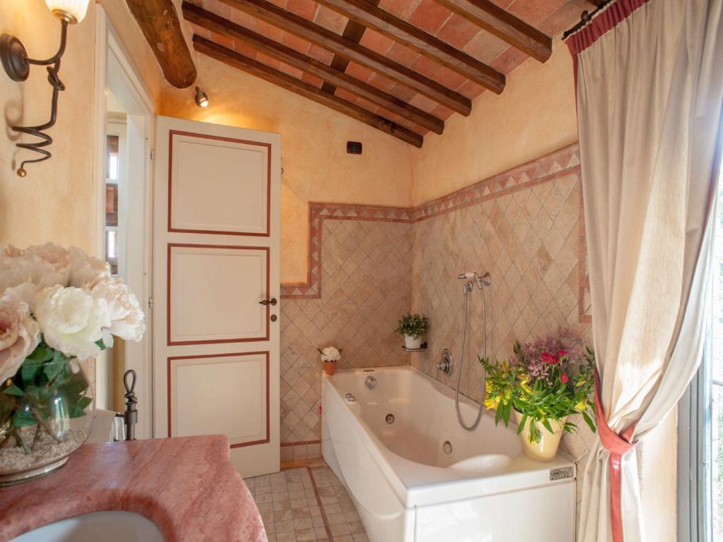 - une salle de bains pourvue d'une baignoire et de fleurs dans l'établissement Villa in Lucca with Pool near Tuscan Coast, à Aquilea 21 autres photos