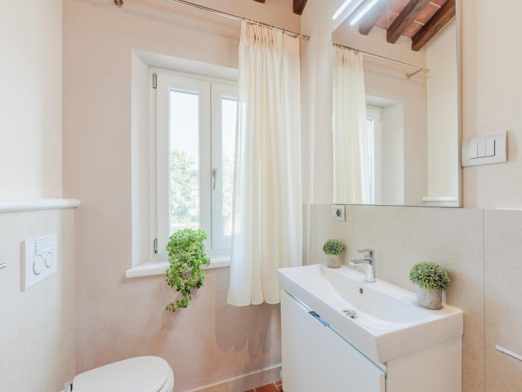 une salle de bain avec un lavabo et des toilettes et une fenêtre dans l'établissement Farmhouse in Lucca with Infinity Pool, à San Ginese