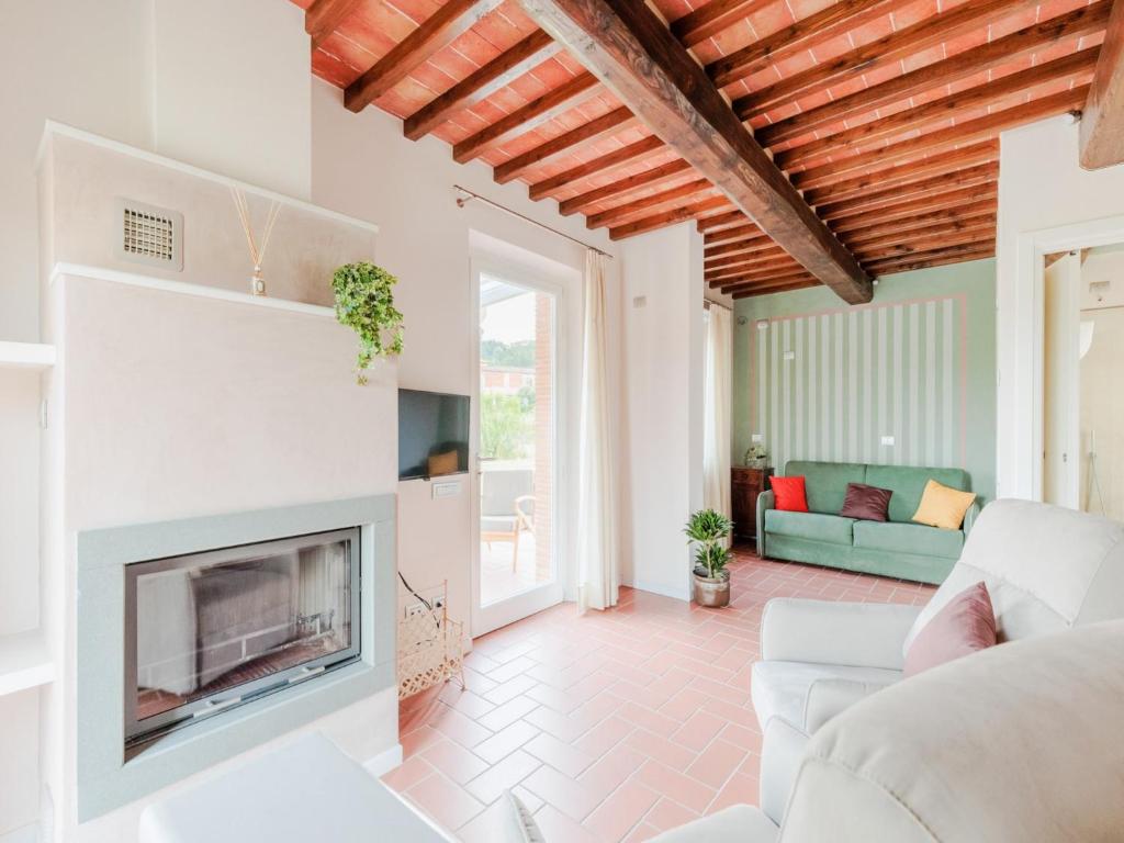 un salon avec une cheminée et un canapé dans l'établissement Farmhouse in Lucca with Infinity Pool, à San Ginese