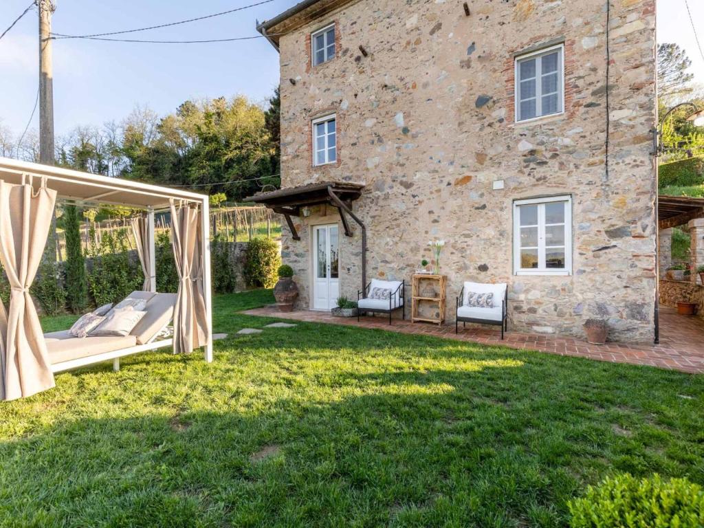 un jardin avec une balançoire devant une maison en pierre dans l'établissement Villa in Tuscany with Private Pool & Hill Views, à Pieve di compito