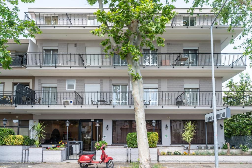 un scooter rouge garé devant un bâtiment dans l'établissement Hotel Giordo, à Rimini