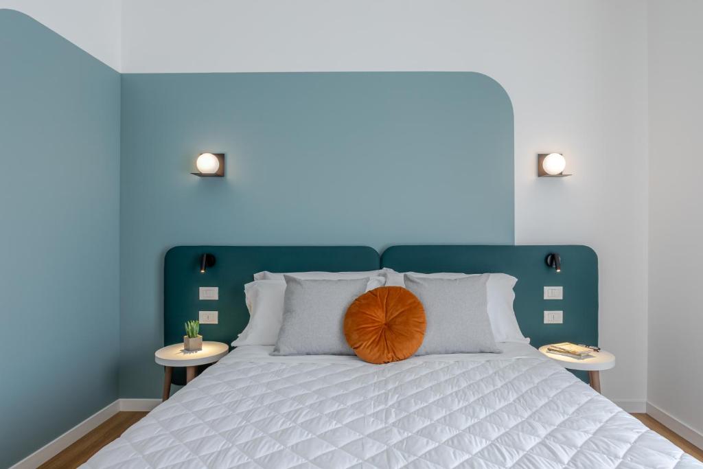 une chambre bleue avec un lit avec une tête de lit en bois dans l'établissement Hotel Mayer, à Lido di Jesolo