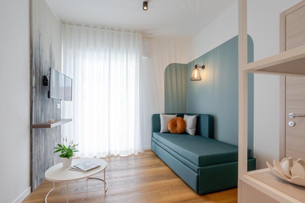 un salon avec un canapé bleu et une table dans l'établissement Hotel Mayer, à Lido di Jesolo