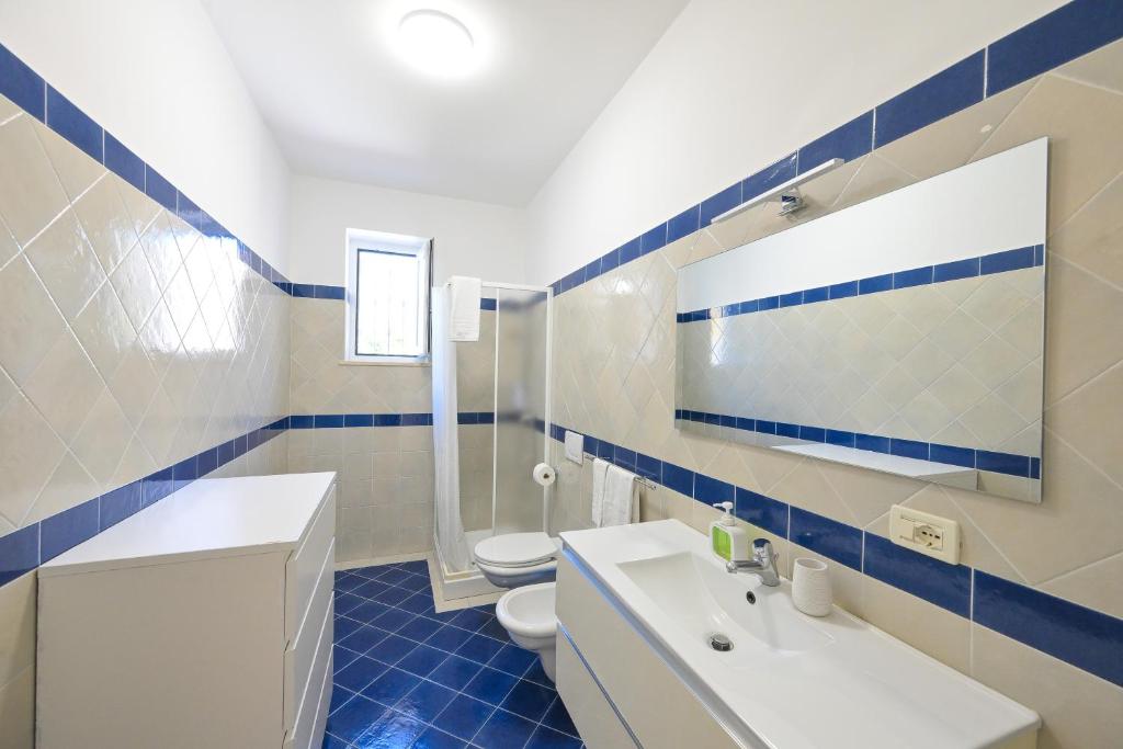 une salle de bain bleue et blanche avec des toilettes et un lavabo dans l'établissement Villa Maddalena Ischia Giardino Privato e Parcheggio - Perfetta per 6 Ospiti, à Ischia